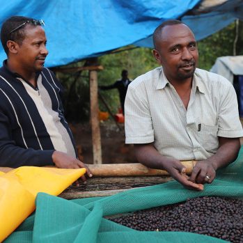 Musefa Abakeno and another man with a sack of coffee