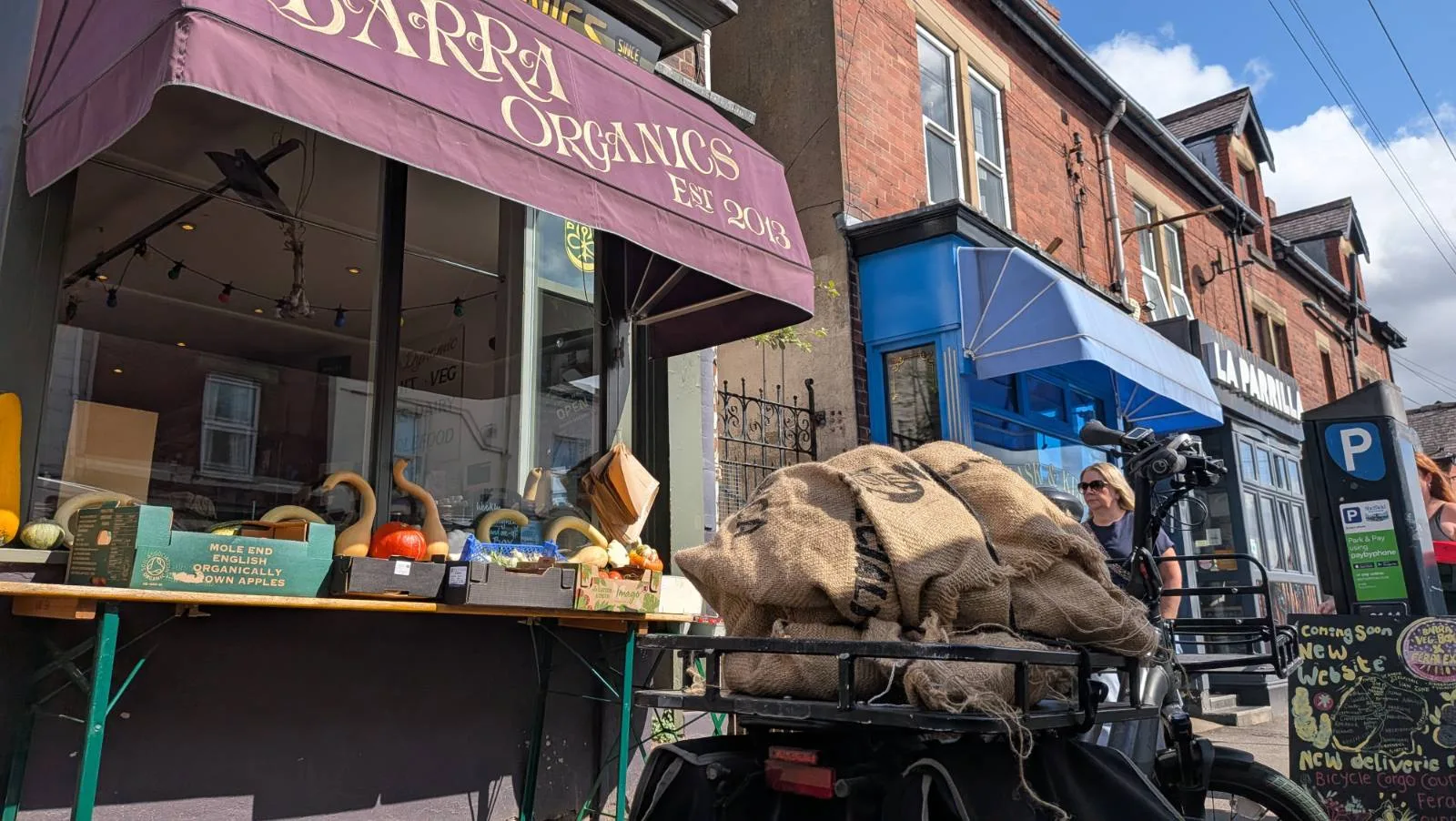 Cargo bike with sack of coffee on rear parked outside Barra Organics shop